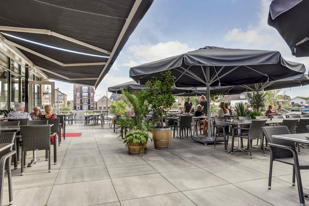 Het terras met parasols en uitzicht over het water
